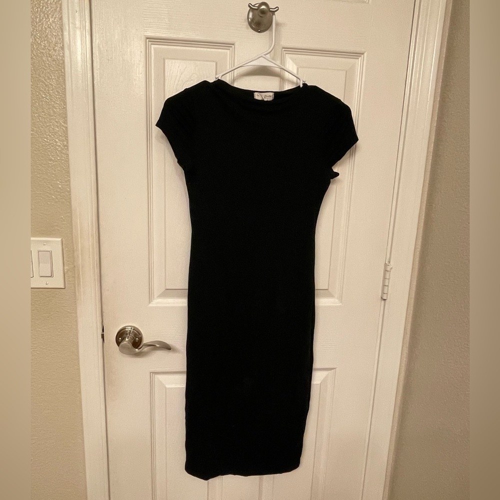 Black above knee length bodycon dress.